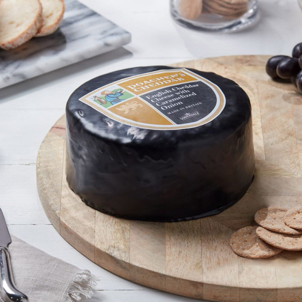 Wheel of Somerdale poacher's cheddar on a wooden board with crackers