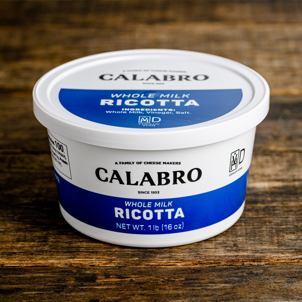 Container of Calabro whole milk ricotta cheese with a wood textured background