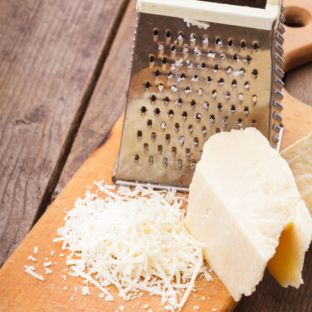 Sanniti shredded parmesan cheese with a grater on the cutting board