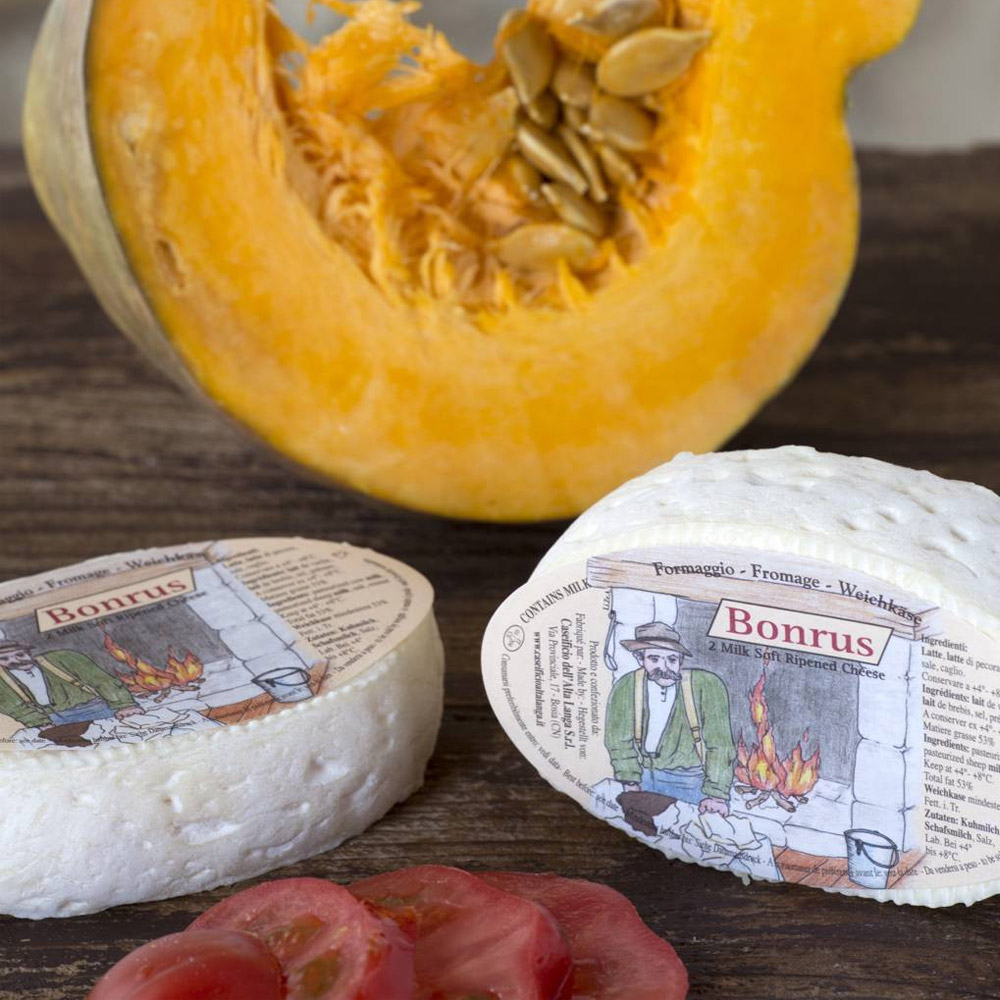 Two pieces of Bonrus cheese on a wooden surface in front of a cantaloupe cut in half