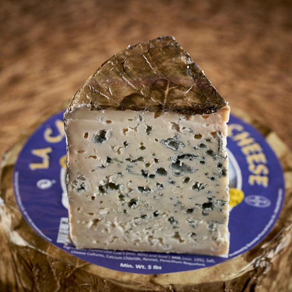 Wedge Valdeón blue cheese on top of a wheel