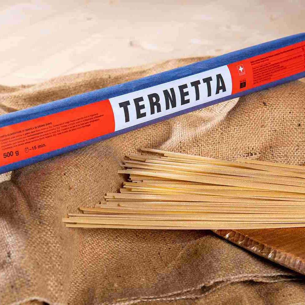A package of Poschiavo Ternetta pasta on top of a burlap sack next to pasta