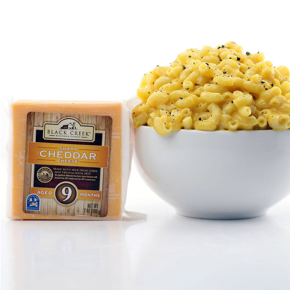 Black Creek Extra Sharp 9 month yellow cheddar next to a bowl of macaroni and cheese