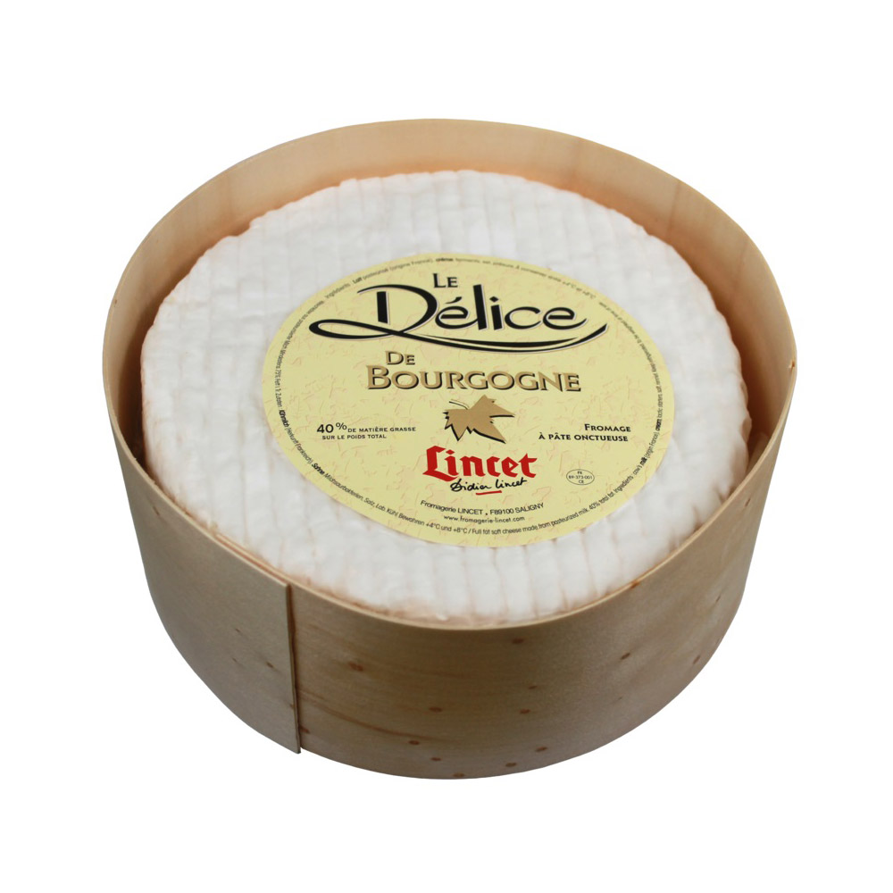 Wheel of Delice De Bourgogne Coupe cheese in a wood container
