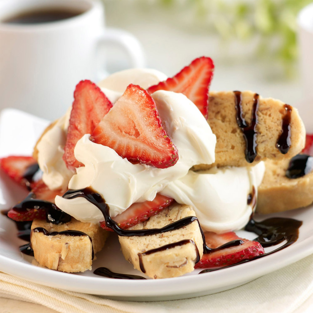 A strawberry biscotti dessert with mascarpone and chocolate sauce on a plate