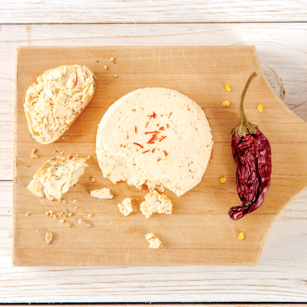Cypress Grove Sgt. Pepper Chevre on a board in between a dried pepper and bread
