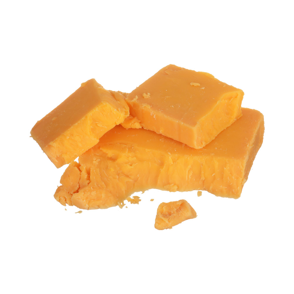 A chunk of yellow cheddar with smaller pieces of cheddar on top