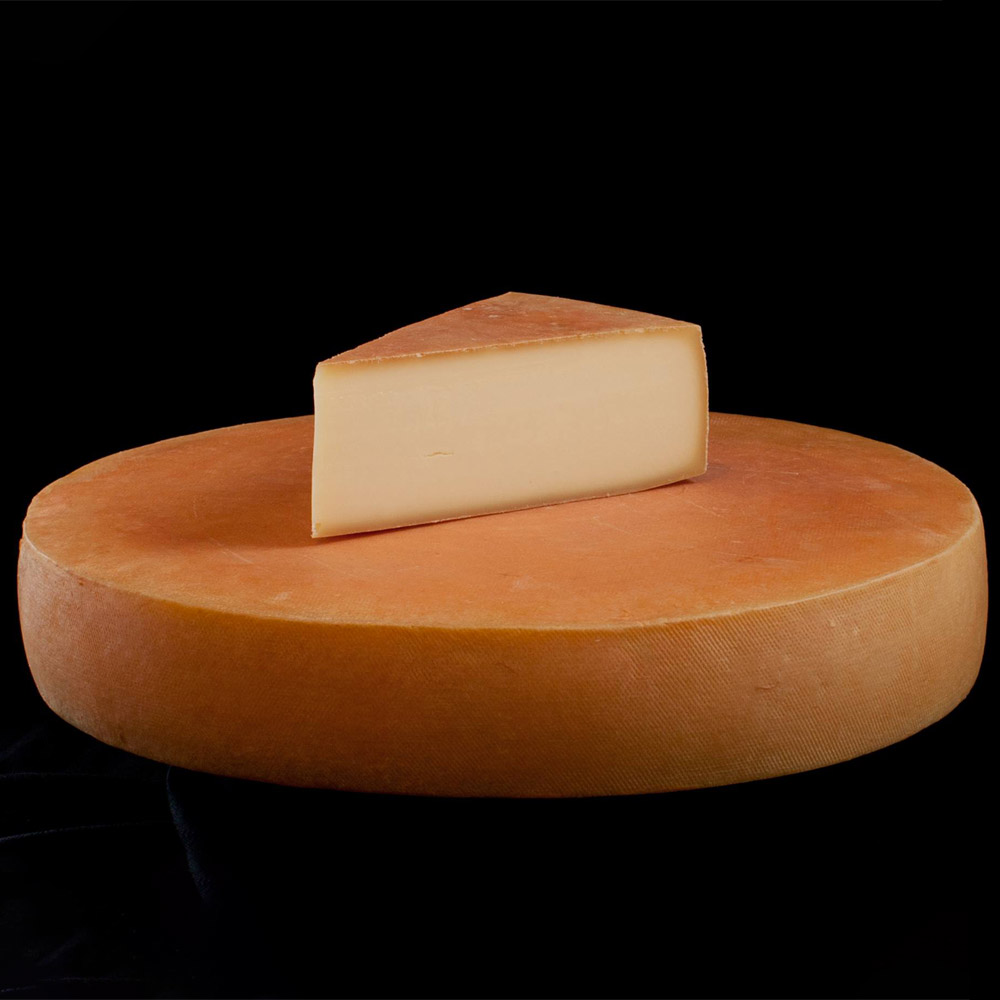 A wedge on top of a wheel of Spring Brook Farm Reading cheese