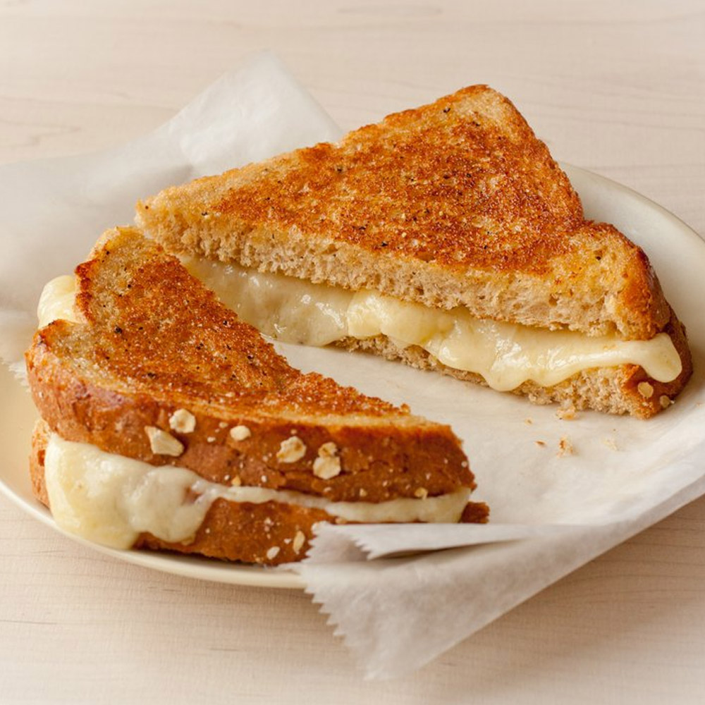 A grilled cheese cut in half on a plate