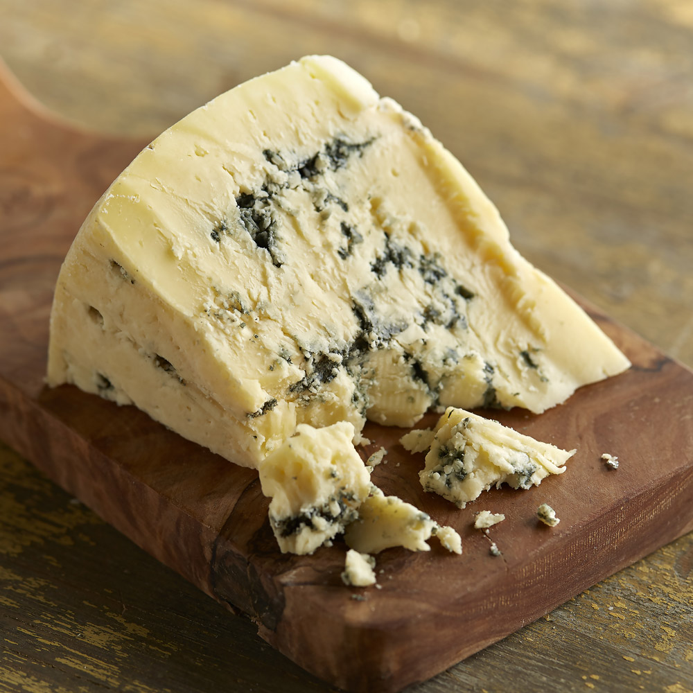 A wedge of Moo & Blue cheese on a board