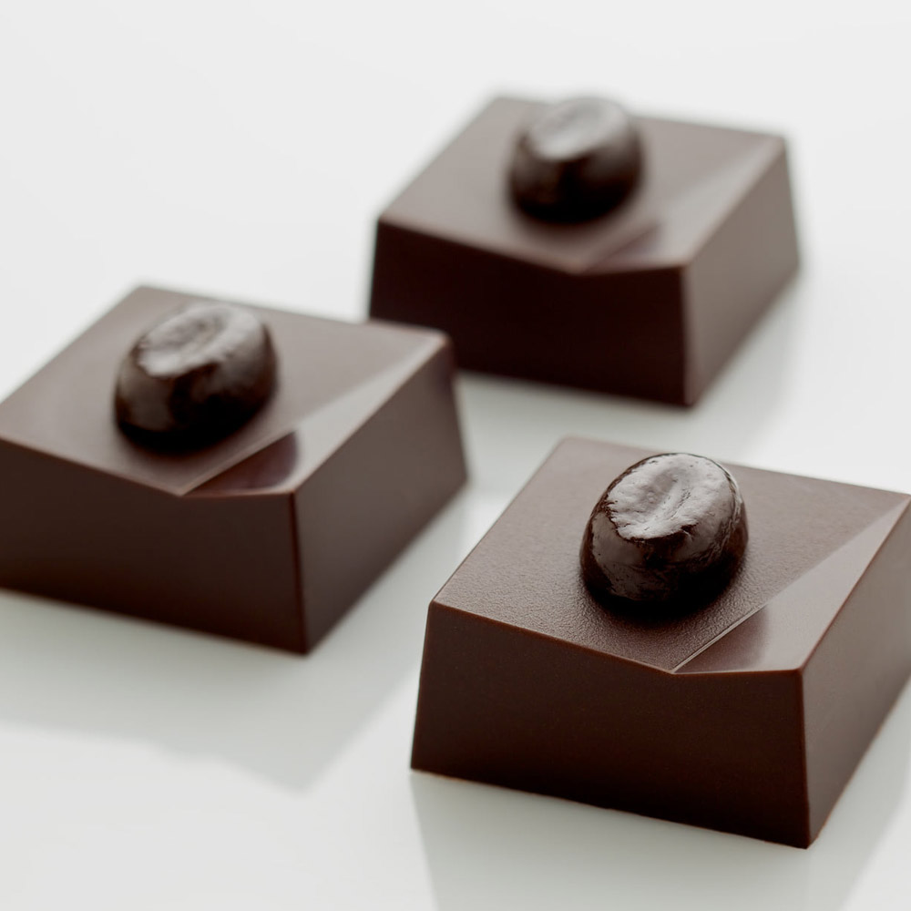 Three dark chocolate bonbons topped with chocolate coffee beans