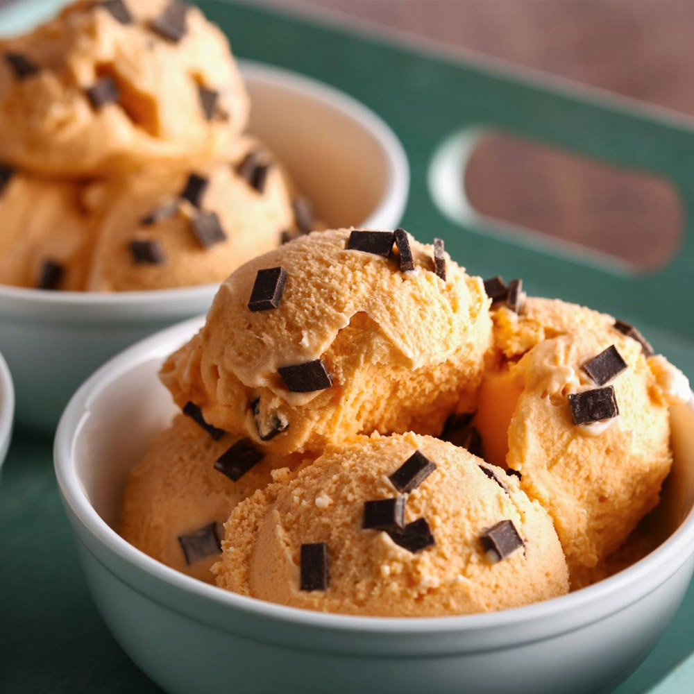 Dark chocolate chunks on a bowl of orange ice cream