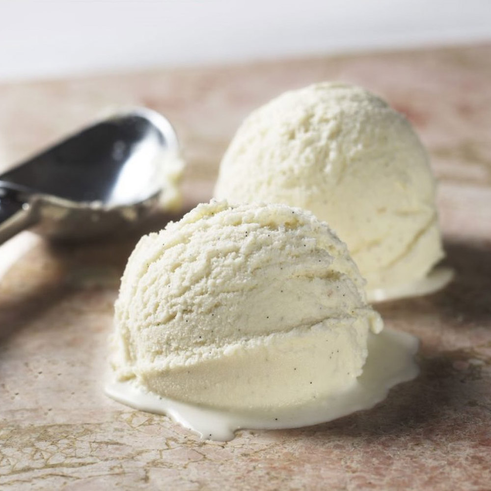 Scoop of vanilla bean ice cream next to an ice cream scoop