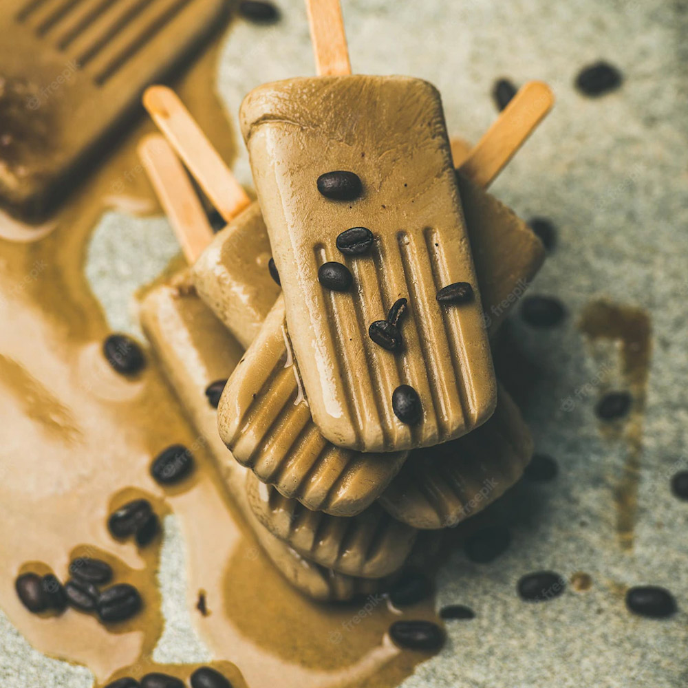 Melting coffee latte popsicles with roasted coffee beans
