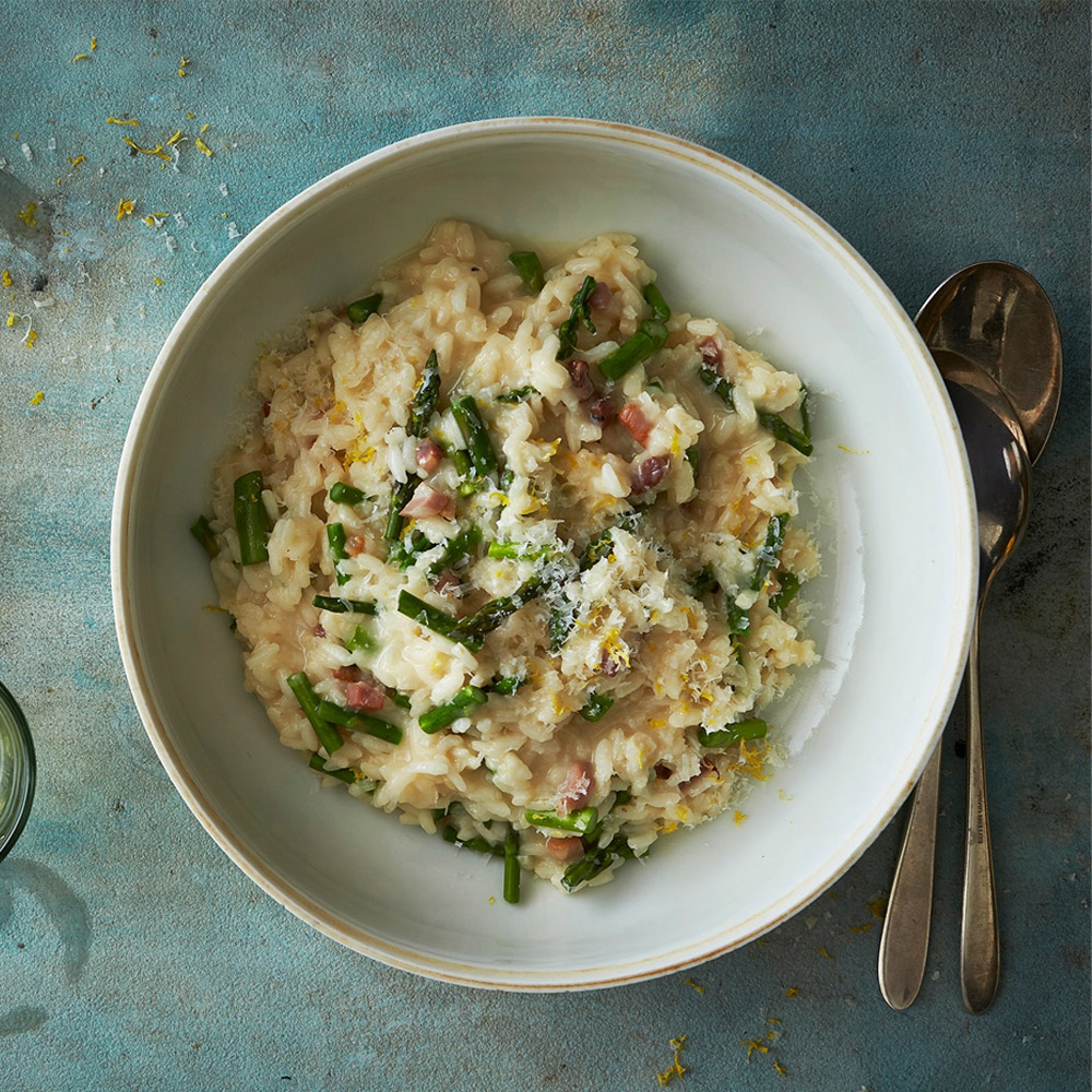 A bowl of risotto with chopped prosciutto on top