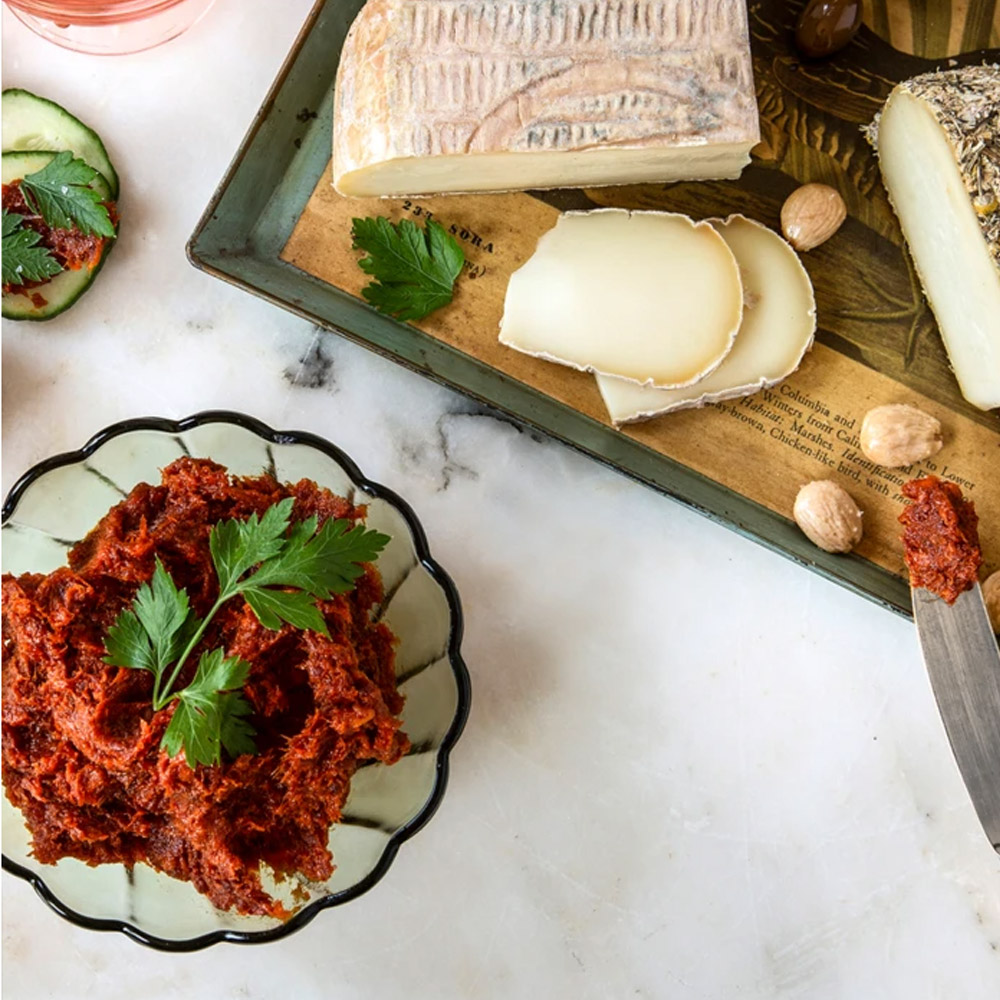 la quercia 'nduja spicy prosciutto spread in bowl with cheese on cutting board and accompaniments