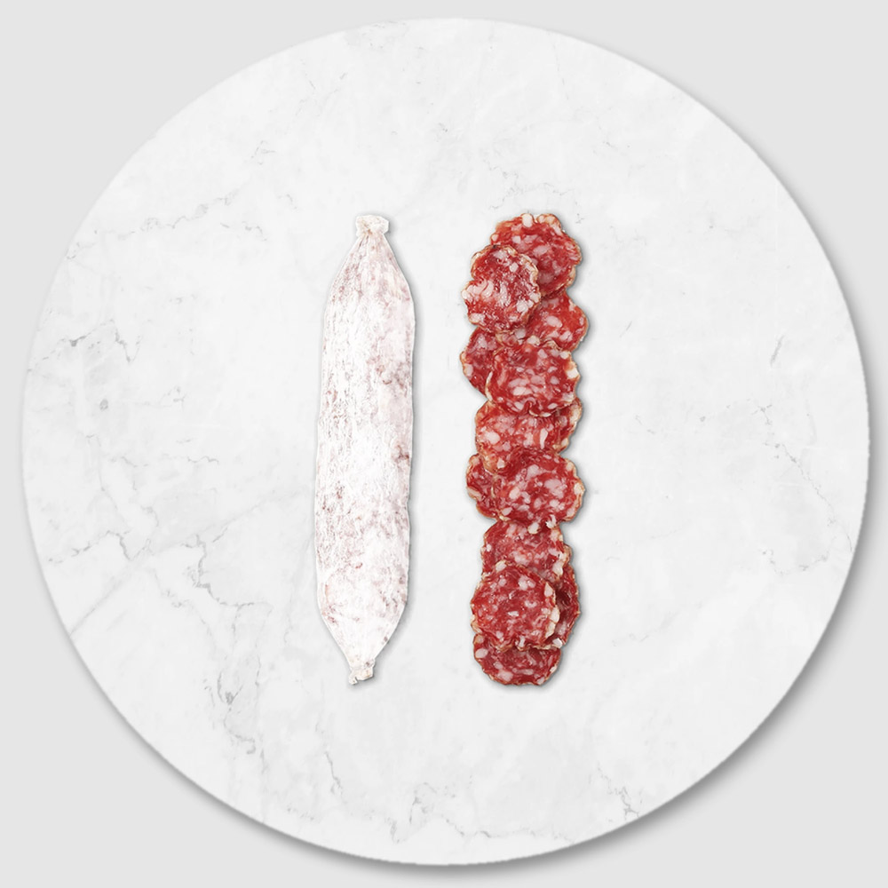 A salami chub next to slices of salami on a marble board