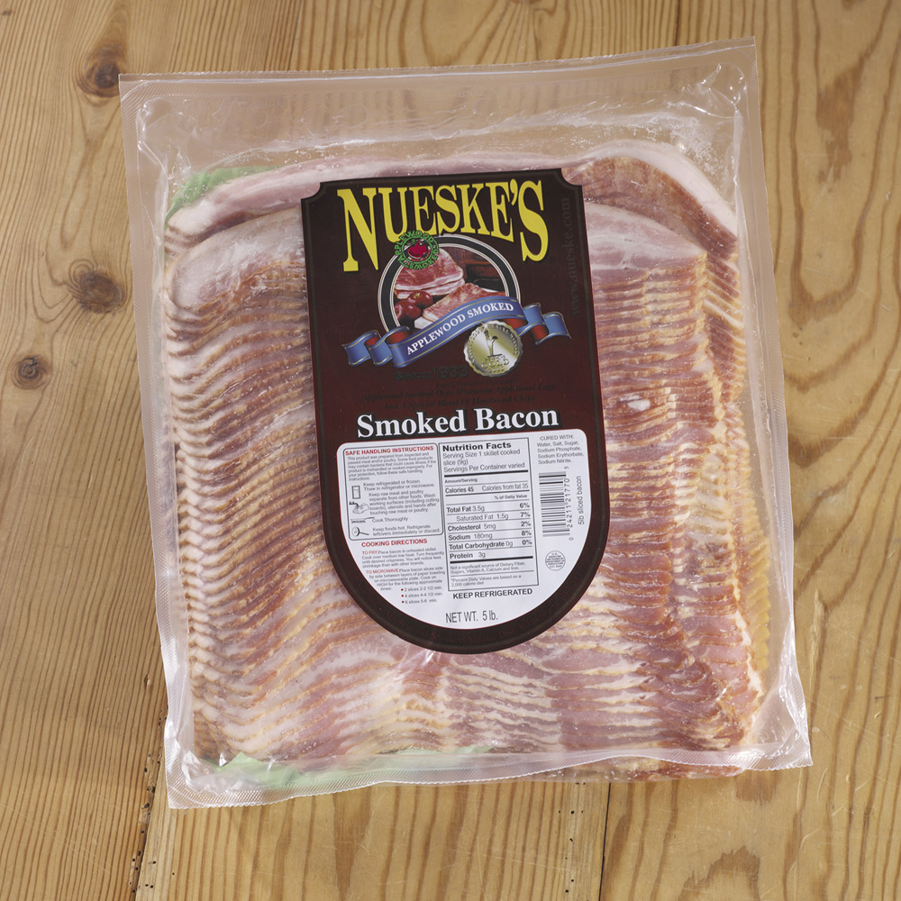 nueske's applewood smoked sliced bacon in plastic packaging on cutting board