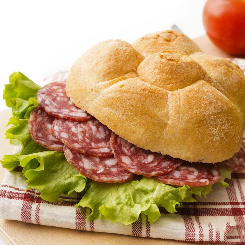 A salami sandwich fanned out on top of a cloth napkin