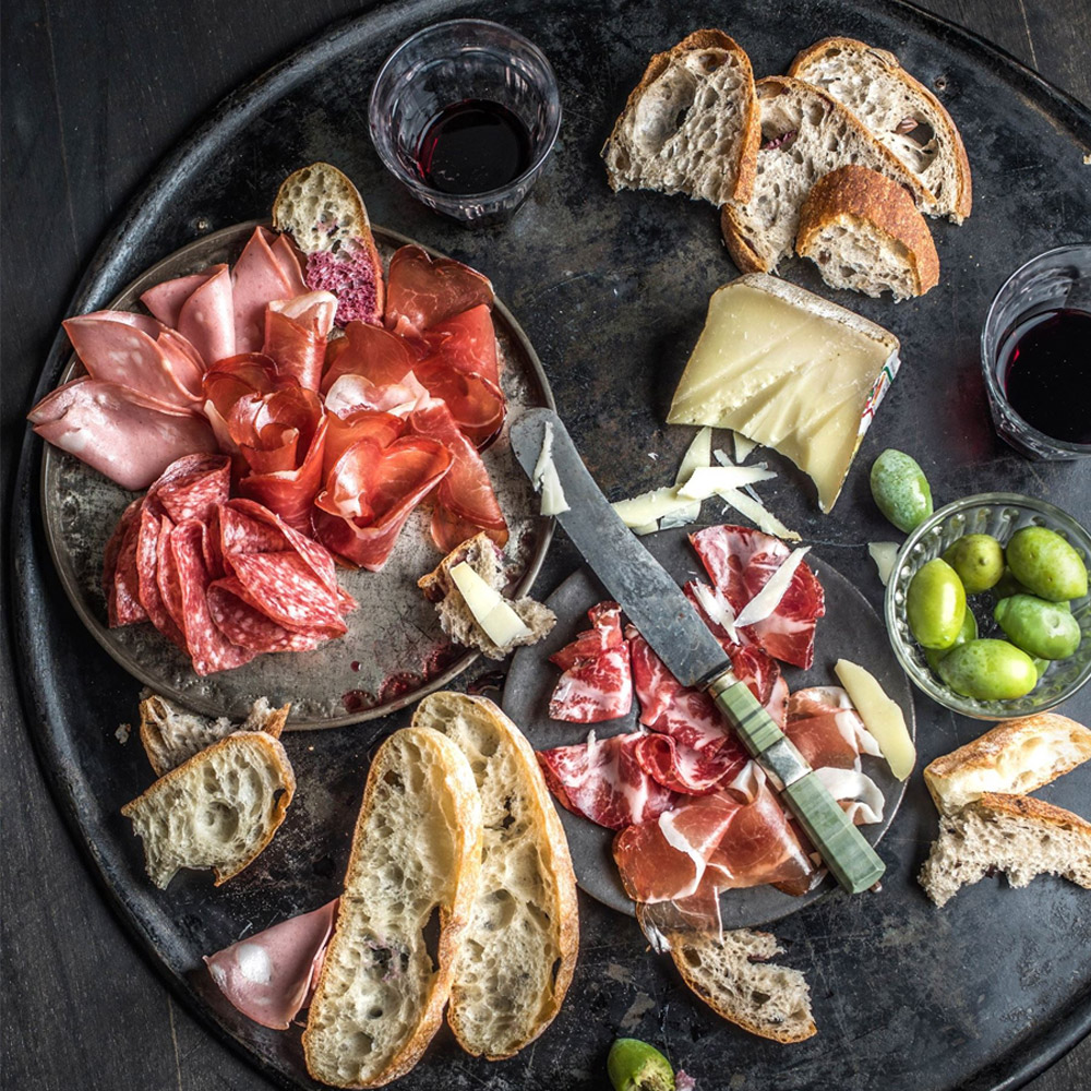 A charcuterie board with wine and cheese