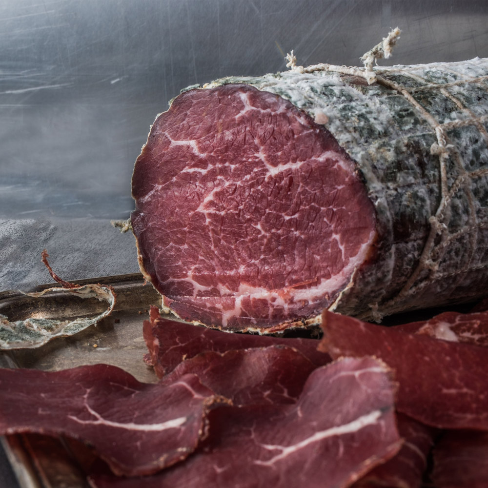 A log of bresaola surrounded by slices of bresaola