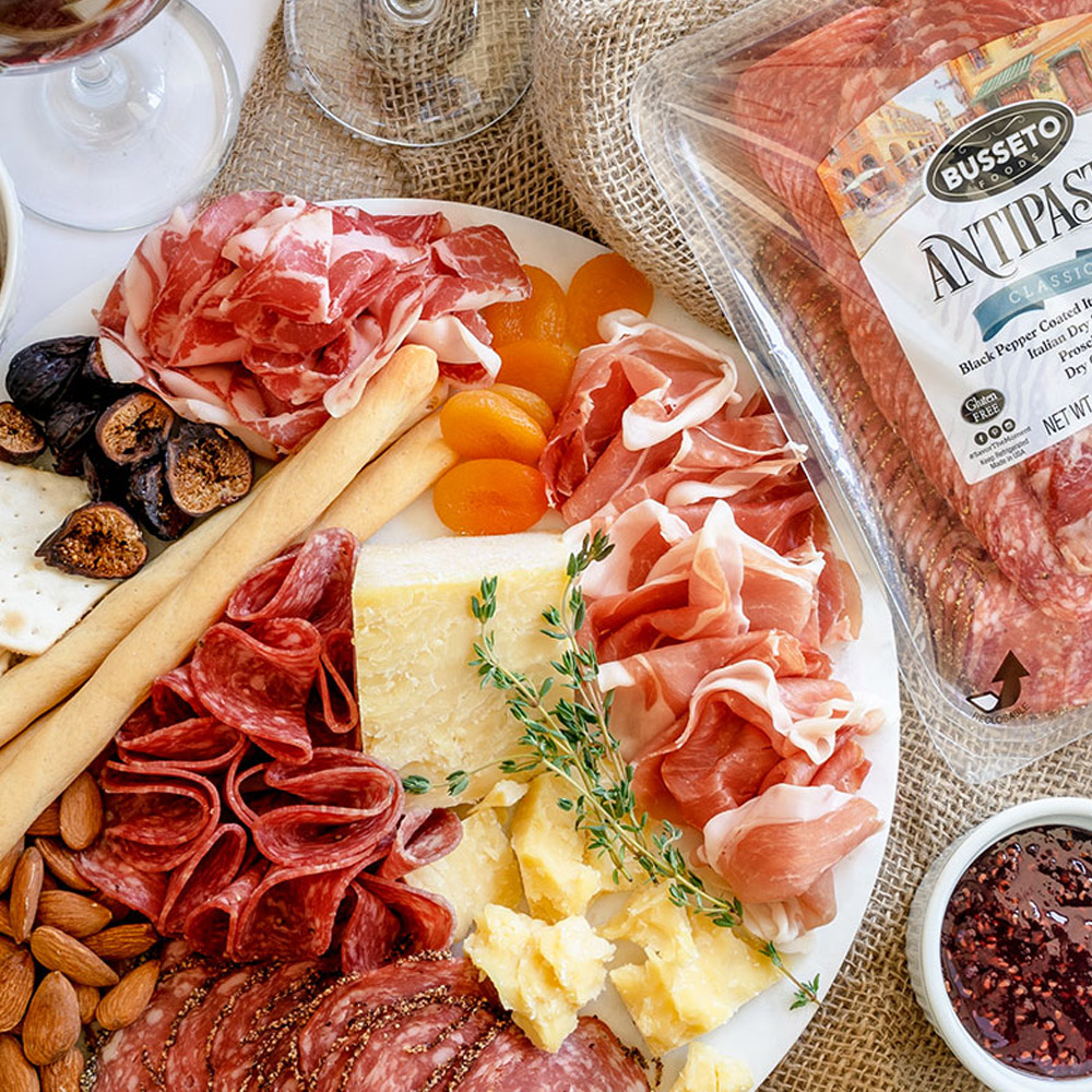 A charcuterie board next to a package of Busseto Antipasto