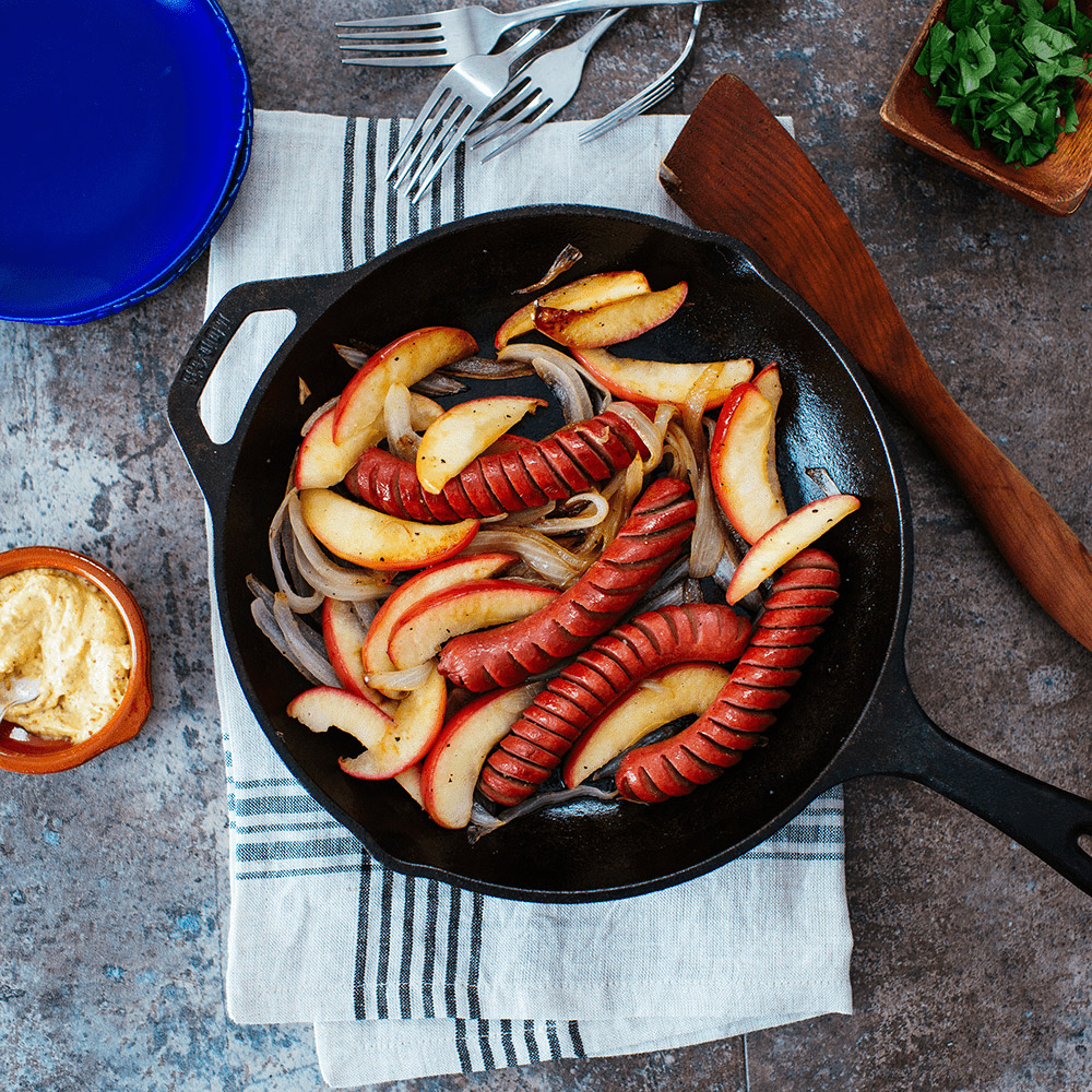 applegate naturals uncured beef hot dogs sliced in skillet with apples and onions
