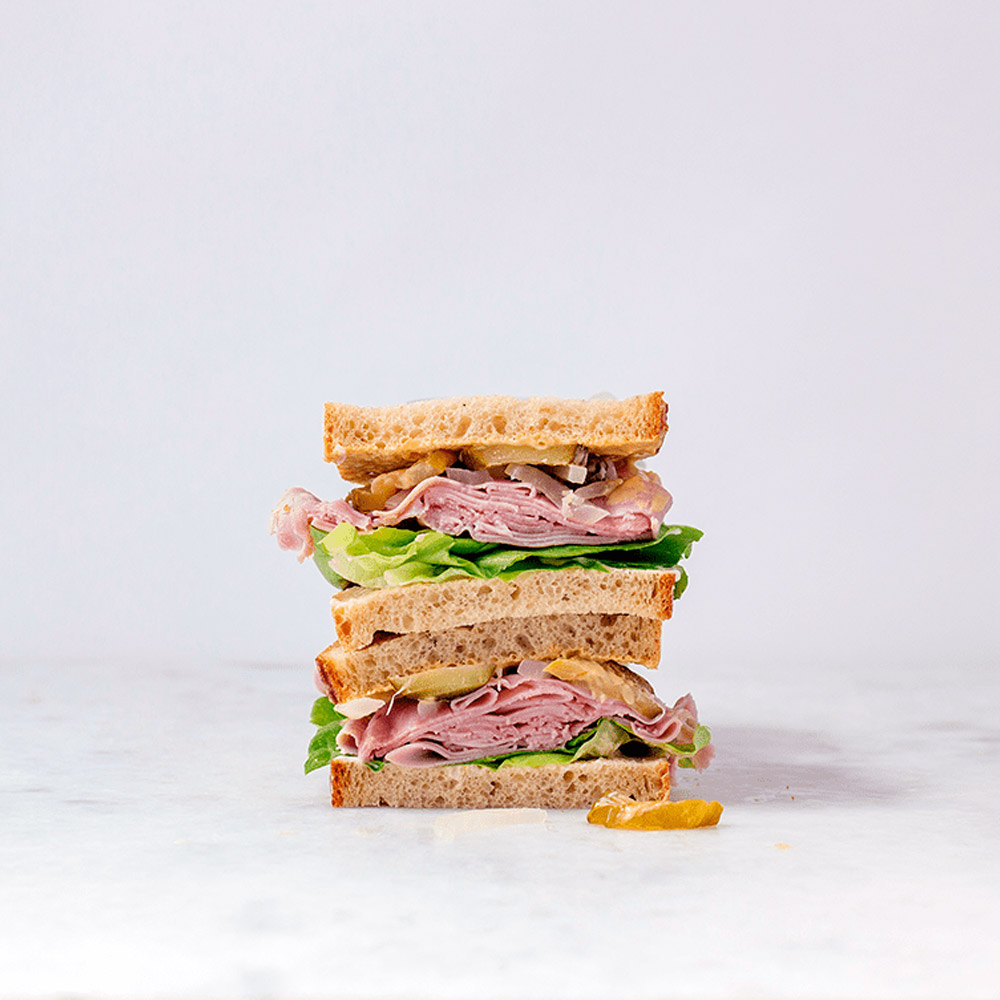applegate naturals sliced slow cooked uncured ham on sandwich with lettuce and accompaniments