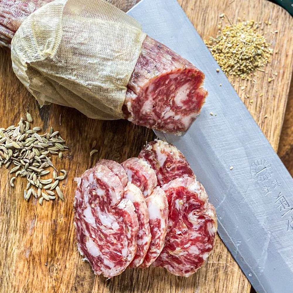 salumi chicago uncured finocchiona salami sliced on cutting board with spices