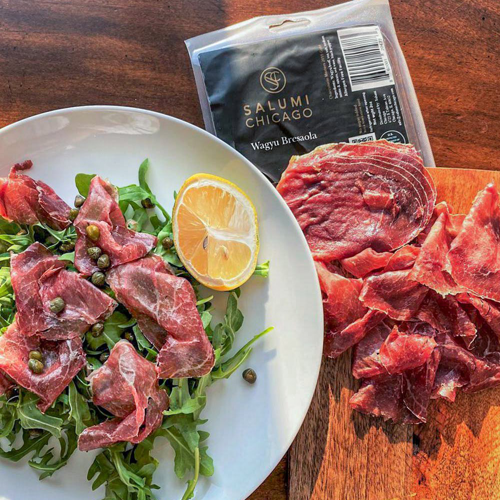 salumi chicago sliced wagyu beef bresaola sliced into salad in plate and sliced on cutting board