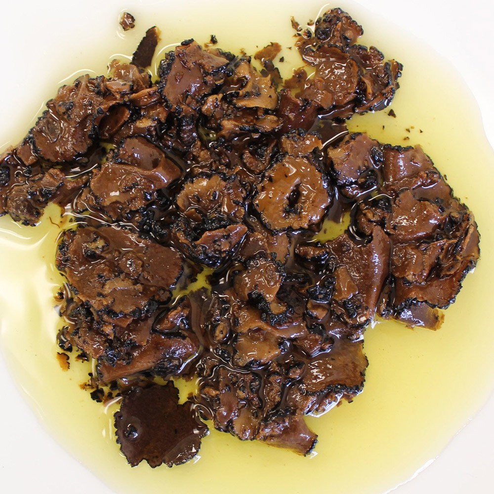 sabatino tartufi sliced black summer truffles in olive oil on plate