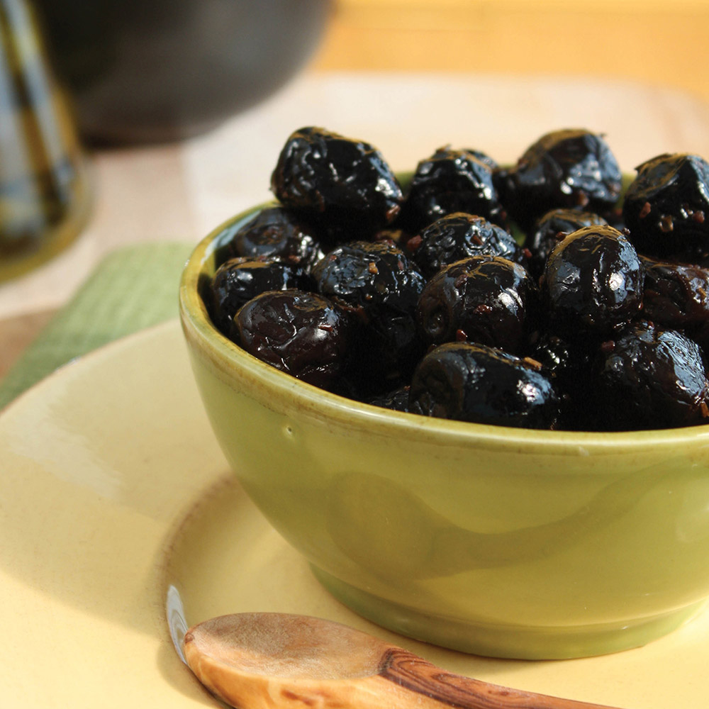 Barnier dry-cured black olives with herbes de provence in a bowl with spoon