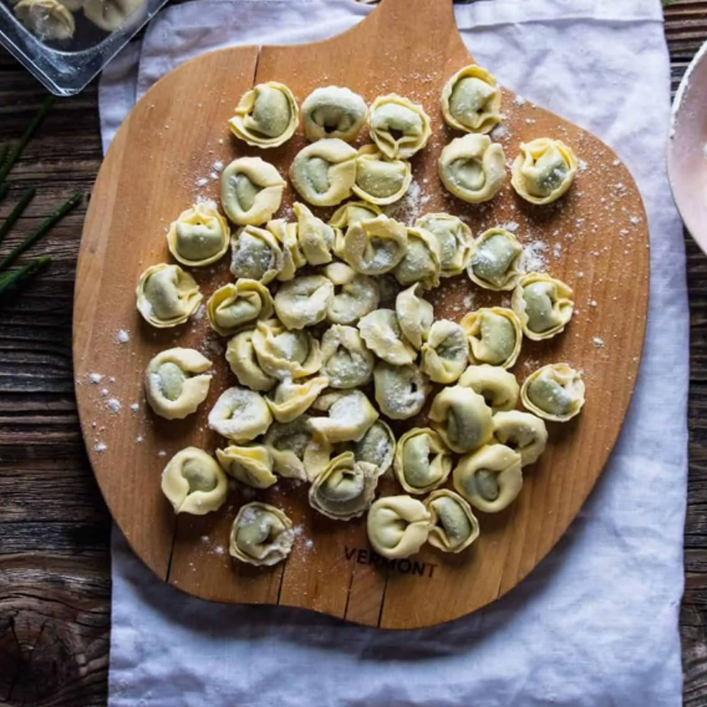 Nuovo pasta organic spinach- and cheese tortellini on wooden cutting board