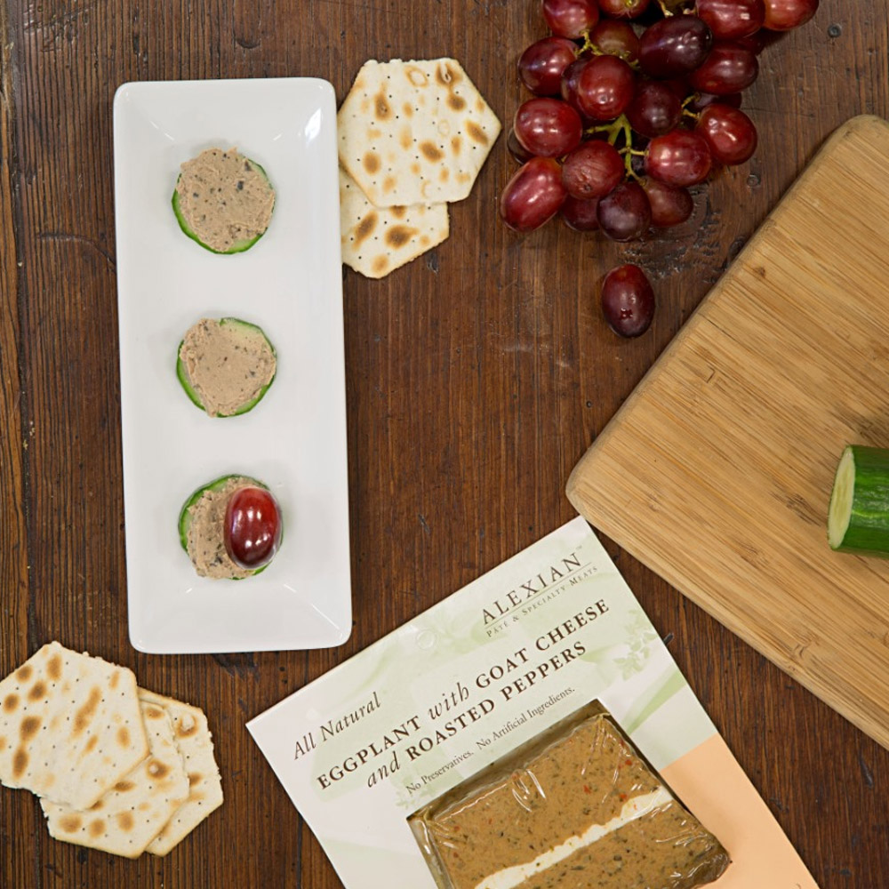 Pate on slices of cucumber next to crackers and grapes