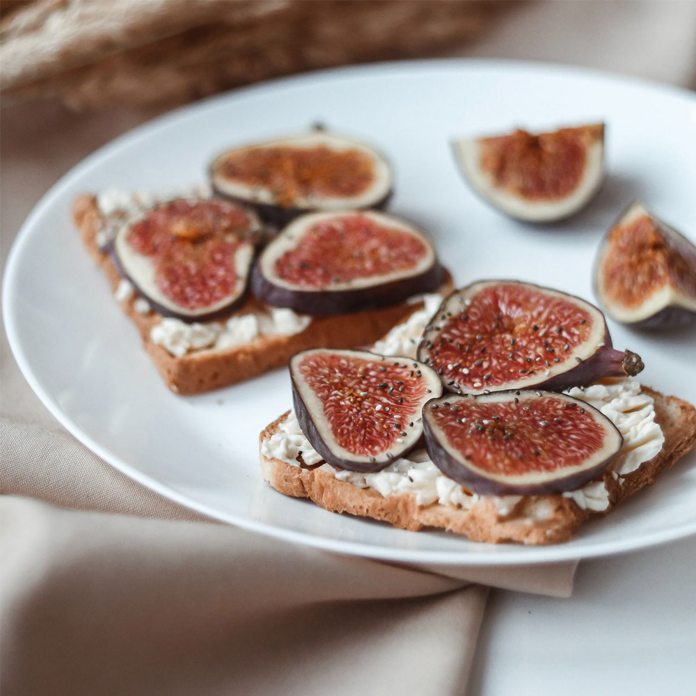 Black peppercorn pate on crackers topped with figs