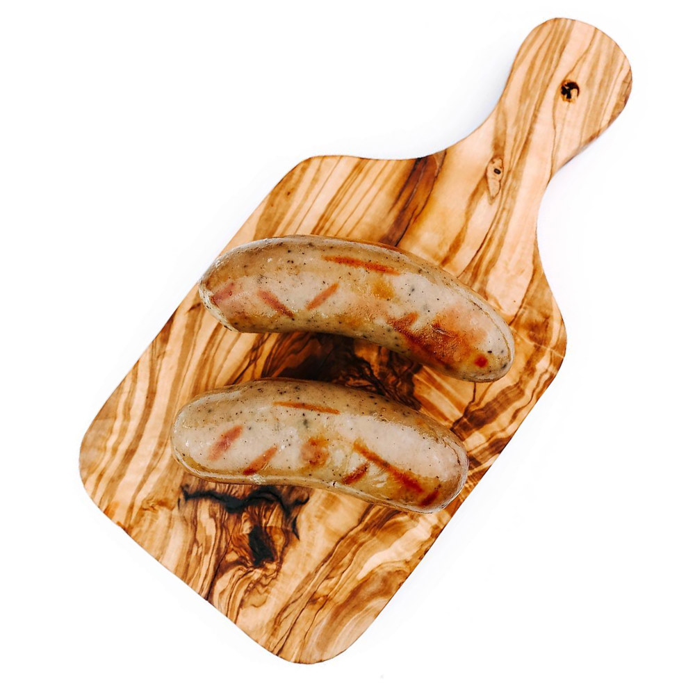 Two cooked bratwurst on a wood board