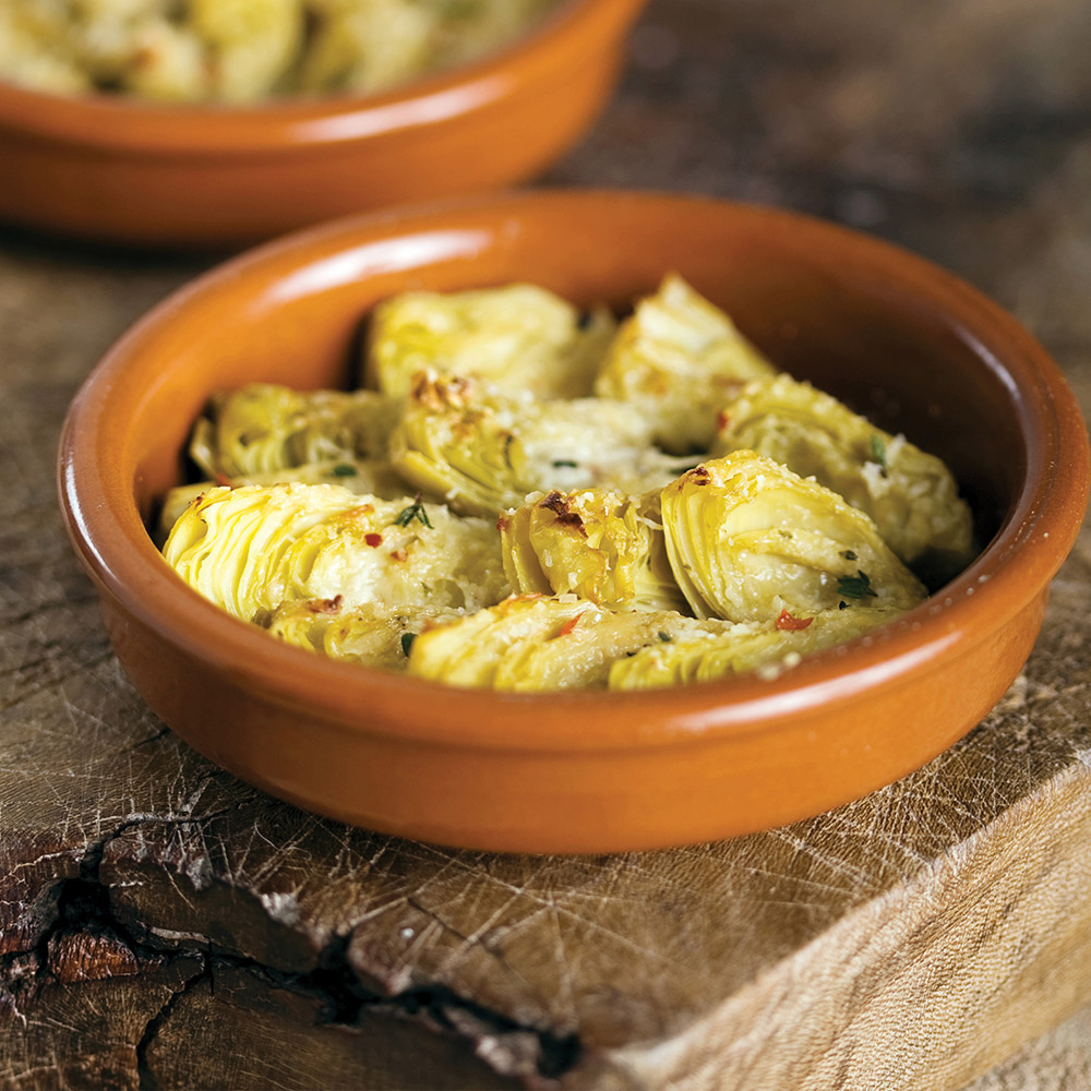 divina marinated artichoke quarters with herbs in bowl