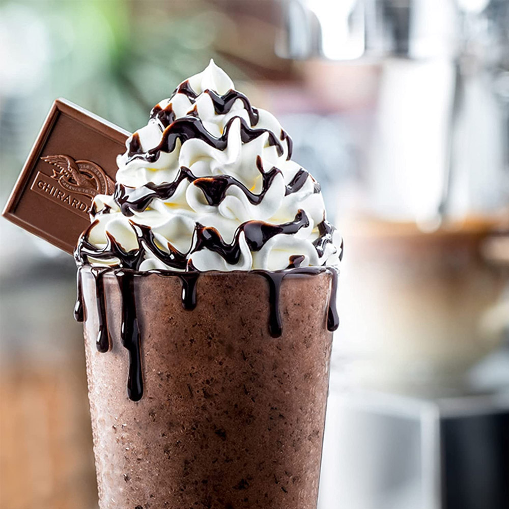 A milkshake topped with whipped cream and chocolate sauce