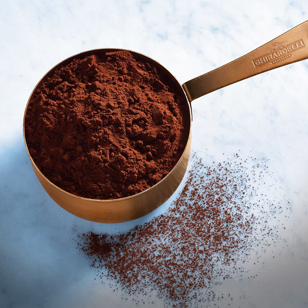 A measuring cup filled with cocoa powder