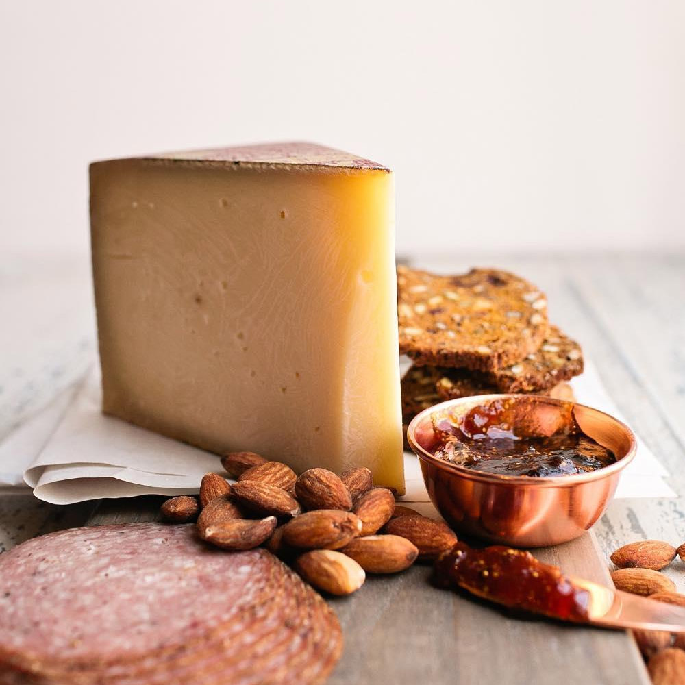 A wedge of Roth Grand Cru Reserve on a cheese board with other snacks