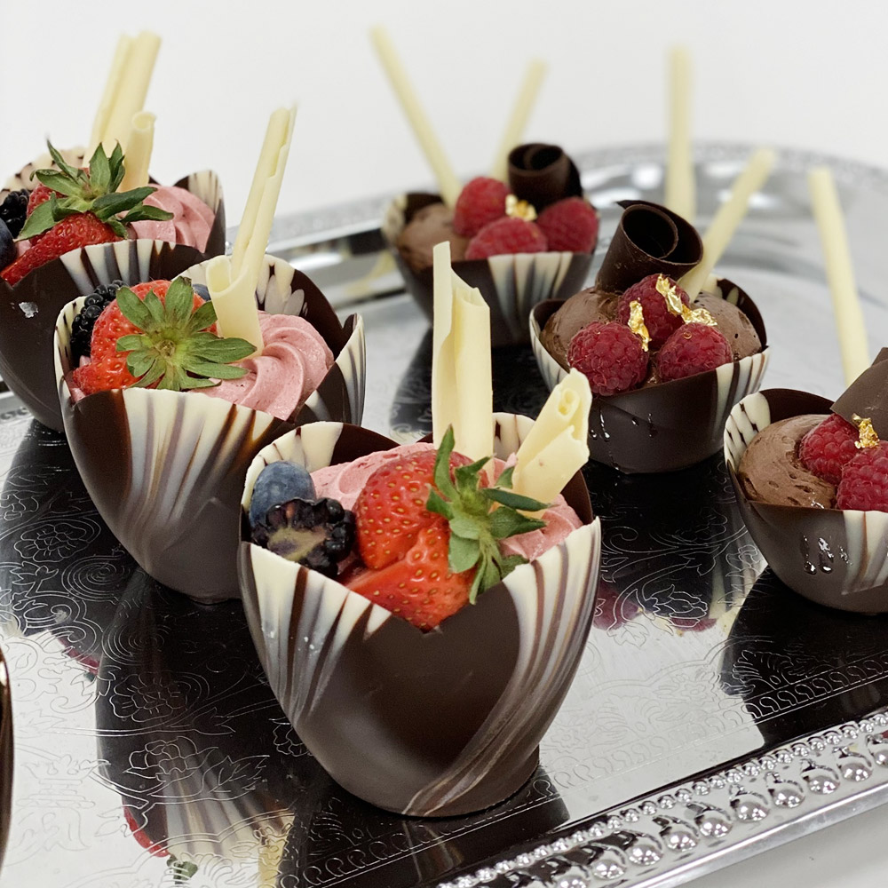 Marble chocolate tulip cups on a tray filled with fruit