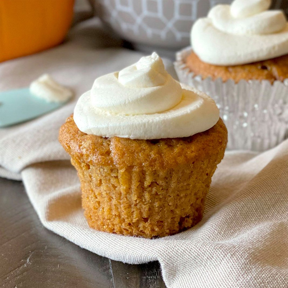 A pumpkin cupcake topped with mascarpone frosting