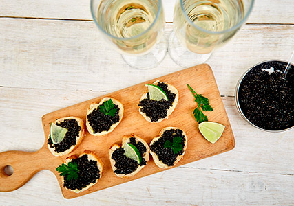 Caviar on bread slices with lime wedges